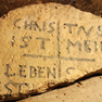 Fragment mit Kreuz und Inschrift, gefunden 1973