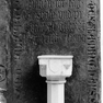 Fragment einer Grabplatte mit den Grabinschriften für Kunigunde Flaeming (Nr. 93) und Heinrich Fläming, vermutlich ihren Ehemann (Nr. 117), an der Südwand östlich neben dem Portal zum Rindermarkt. Mehrfachverwendung der Platte. Rotmarmor. Reste eines Wapp