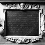 Rollwerktafel mit einer zwölfzeiligen Grabinschrift auf dem Postament des Epitaphs.
