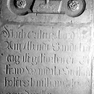 Fragment der Grabplatte für Wandala Hofer oder ...hofer, an der Westwand des Querhauses, vierte von Süden, neben der Tür zur Sakristei, Mitte. Rotmarmor.
