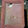 Bibelzitat und Baudatum auf einer Tafel aus rotem Sandstein.
