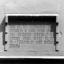 Bauinschrift auf einer Tafel aus rotem Sandstein außen am Treppenturm der Westfassade.