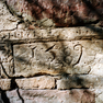 Jahreszahl und Steinmetzzeichen auf einem Steinquader auf der Rückseite des Hauses.