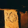Im Keller verbauter Grenzstein mit zwei Wappen und einer Jahreszahl auf der Vorderseite.
