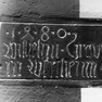 Name als Bauinschrift auf einem Eckquader aus rotem Sandstein außen in der Turmsüdwand.