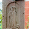 Reliefbildnis auf der Schmalseite des Kreuzsockels zeigt die Frau des Stifters.
