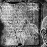 Figurale Grabplatte für den Hofnarren Hans Gerl, an der Südwand in der Westecke. Rotmarmor mit Inschriftplatten in hellem Kalkstein.