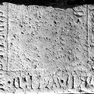 Unteres Drittel einer Grabplatte aus Kalkstein, ehemals vermutlich im Kreuzgang.