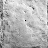 Sehr abgetretene Grabplatte aus Sandstein, im Boden eingelassen.