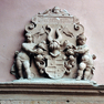 Name und Jahreszahl als Bauinschrift auf einer Wappentafel aus rotem Sandstein über dem Portal in der Südwestecke des äußeren Burghofs.