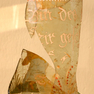 Zusammengesetzte Fragmente eines Glashumpens mit Figur und weiß gemalter Inschrift.