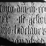 Fragment der Grabplatte für Hans Hidelauer. Rotmarmor.