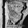 Fragment einer Wappengrabplatte für Wilhelm Triebenbacher und seine Ehefrau Apollonia, geb. Aigner, an der Südwand im siebenten Joch von Westen, untere Platte. Rotmarmor.