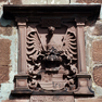 Jahreszahl und Namen als Bauinschrift auf einer Wappentafel über dem Eingang zur Burg.