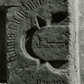 Der untere Teil einer Wappengrabplatte des Hans Ziegelma(nn ?) aus Kalkstein, heute an der Wand aufgerichtet.
