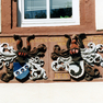 Namensinschriften und Jahreszahl auf einer Wappentafel auf der Frontseite des Hauses im Obergeschoß.