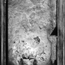 Grabplatte mit fragmentarischer Grabinschrift für einen Bürger, an der Westwand, neunte Platte von Norden, hinter einem Beichtstuhl. Rotmarmor.Unten Wappenrelief in Vierpass.