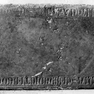 Fragment einer Grabplatte für Diemut, die Ehefrau eines Rudolf Preninger, im Heizungskeller der Kirche. Rotmarmor.