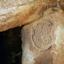 Im Keller verbauter Grenzstein mit einem Wappen auf der Rückseite. 