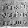 Fragment einer Grabplatte, an der Westwand, zweite Platte von Norden, untere Reihe. Rotmarmor.