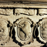 Drei von sechzehn Wappenschilden mit Beischriften im Sockelfeld des Epitaphs.