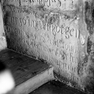 Fragment einer Grabplatte mit den Grabinschriften für eine unbekannte Frau (Nr. 467) und für Helena Deterholzer (Nr. 538), an der Nordwand im ersten Abschnitt von Westen, untere Platte. Rotmarmor.